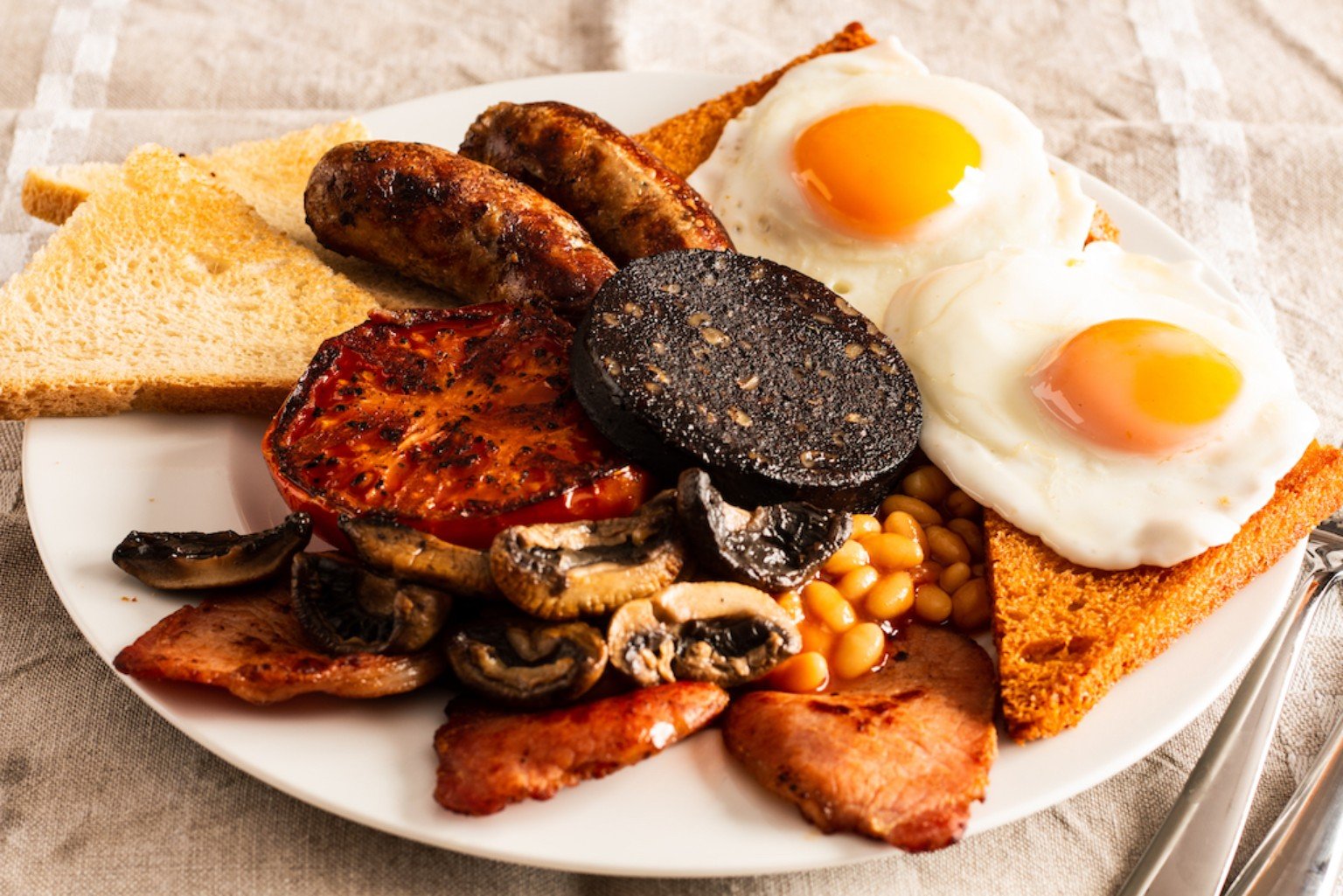 Full English breakfast with eggs, sausages, bacon, beans, mushrooms, tomatoes and toast